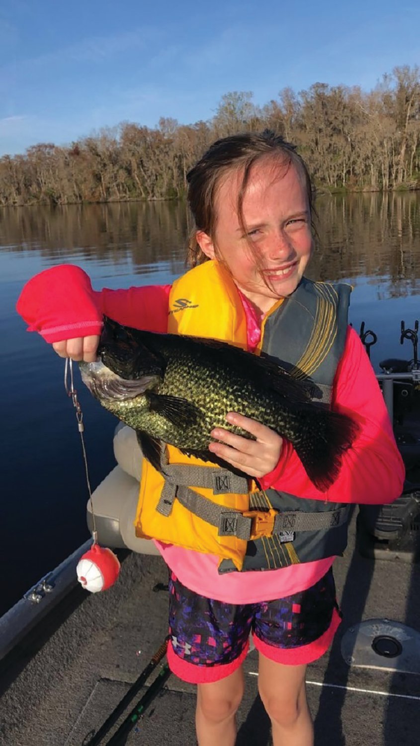 A girl holds a black crappie, also called “Speckled Perch.”